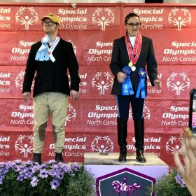 North Carolina Special Olympics Equestrians Robert Earl McCarter of Mecklenburg, and Tisbe Pizani of Charlotte, pose with the ribbons they won during the 2022 event at the Tryon International Equestrian Center. Photo by Catherine Hunter.